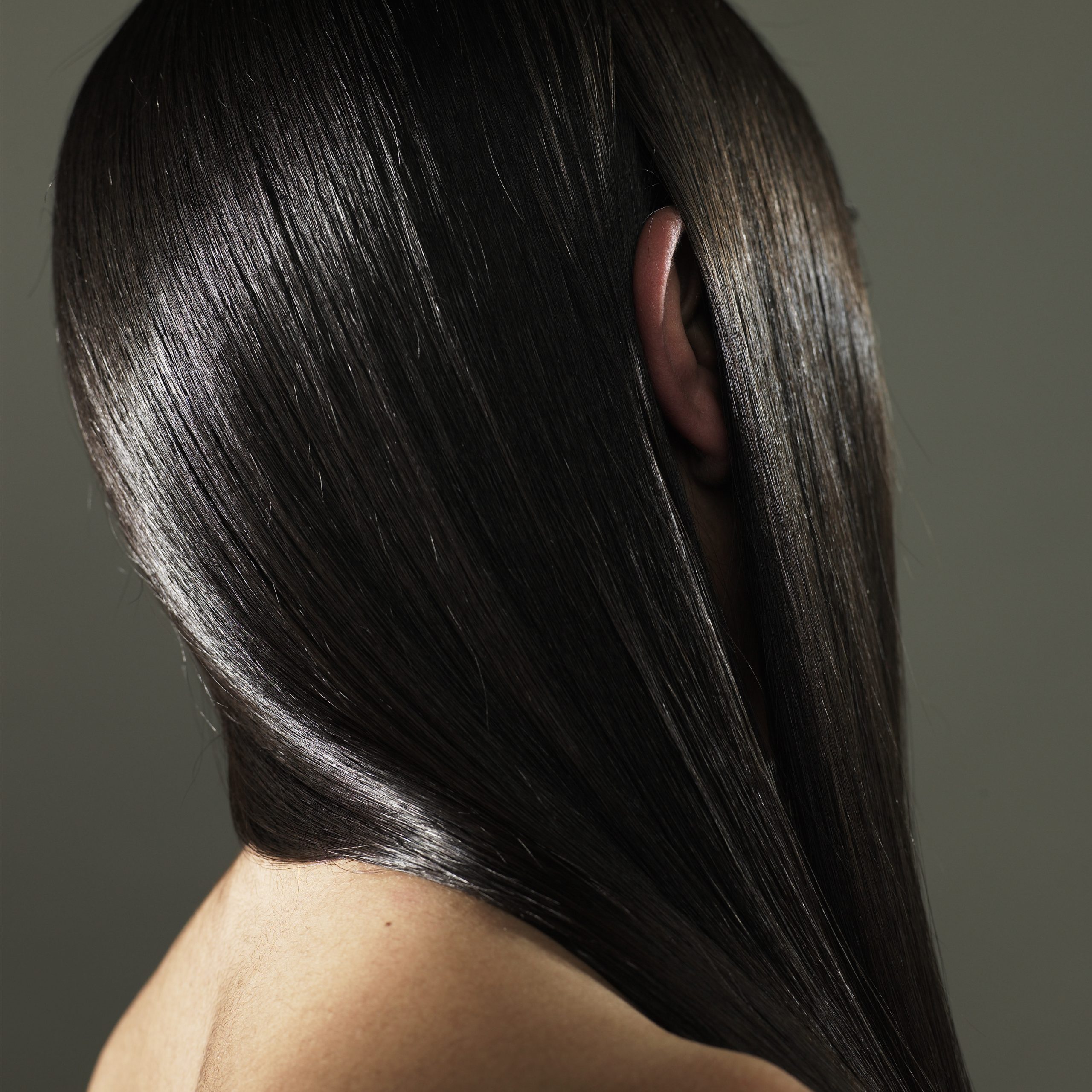 Young woman with ear sticking out of long hair, side view